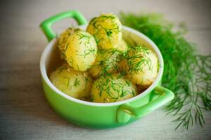 gekookt vroeg aardappelen met boter en vers dille in een kom foto