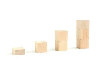 bedrijf concept groei succes werkwijze, statistieken grafiek. houten blokken stapelen net zo een pijl omhoog gemiddelden net zo een groei diagram tabel Aan wit achtergrond. foto