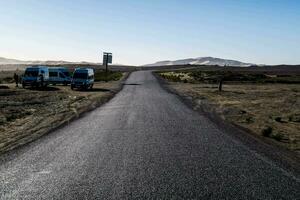 twee bestelwagens geparkeerd Aan de kant van een weg in de woestijn foto