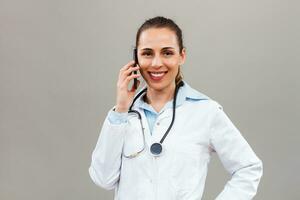 mooi vrouw dokter gebruik makend van mobiel telefoon. foto