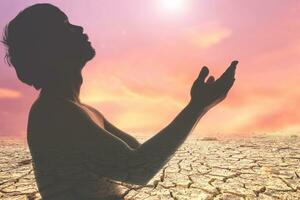 bidden voor regenen, vragen voor water naar overleven de water tekort crisis. concept van bidden naar god. silhouet van een Mens bidden. foto