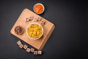 rauw durum tarwe gnocchi pasta met zout en specerijen in een keramisch bord foto