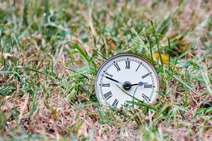 een oud klok in de gras foto