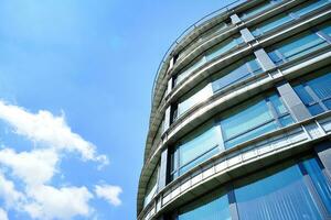 glas gebouw met transparant facade van de gebouw en blauw lucht. structureel glas muur reflecterend blauw lucht. abstract modern architectuur fragment. hedendaags bouwkundig achtergrond. foto