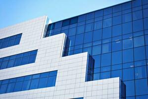 glas gebouw met transparant facade van de gebouw en blauw lucht. structureel glas muur reflecterend blauw lucht. abstract modern architectuur fragment. hedendaags bouwkundig achtergrond. foto