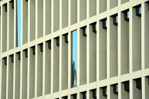 modern kantoor gebouw in de stad met ramen en staal en aluminium panelen muur. hedendaags reclame architectuur, verticaal convergeren meetkundig lijnen. foto