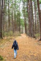 kind loopt over een pad door het bos foto