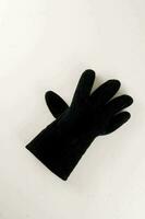 een zwart handschoen Aan een wit oppervlakte foto