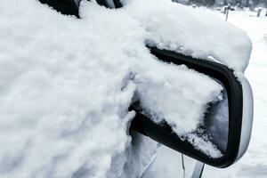 auto in winter in de sneeuw, schoonmaak de auto foto