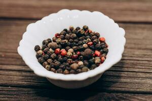 zwart, geurig, rood peper specerijen in kommen Aan een houten tafel. foto