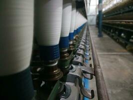 spinnen katoen in garen in een fabriek. werkwijze katoen in draad. foto