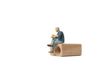 miniatuur mensen zakenman zittend op een houten stoel geïsoleerd op een witte achtergrond foto