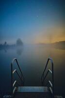 trap in meer geschikt voor zwemmen Bij nacht met mist foto