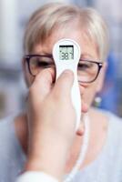 thermometer tonen lichaam temperatuur van ziek volwassen geduldig vrouw in ziekenhuis gedurende medisch inspectie. overleg voor infecties en ziekte gedurende globaal grieppandemie, hulpmiddel, ziekte. foto