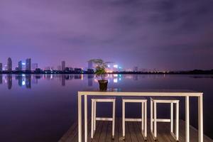 een stad die 's nachts wordt weerspiegeld door het meer foto