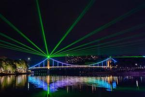 's nachts reflecteert de stroom de kleurrijke lichten op de brug foto