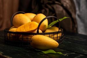 gesneden en intacte mango's op de donkere achtergrond