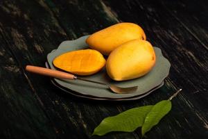mango's snijden en afmaken op een bord in een donkere omgeving foto