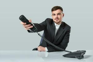 portret van aantrekkelijk zakenman Holding telefoon in zijn hand. deze telefoontje is voor u concept foto