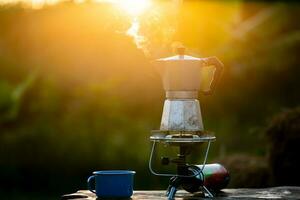 mokka pot en rook, stoom- van de koffie pot Aan vuur, in de Woud Bij zonsopkomst in de ochtend. zacht focus. Ondiep focus effect. foto