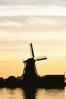 populair toerist plek zaanse schans is in de buurt Amsterdam in de west van de nederland. historisch, realistisch windmolens gedurende zonsopkomst. van nederland mijlpaal foto