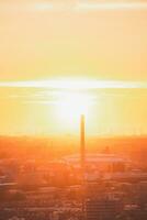 zon instelling over- de horizon in Rotterdam. rood licht bestraling van de wind boerderij en de haven. zonsondergang in Nederland foto