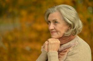 senior vrouw wandelen in de park in herfst. foto