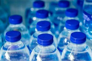 mineraal water flessen in een rij met blauw petten foto