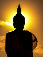 silhouet achter een standbeeld van Boeddha in de tempel. foto