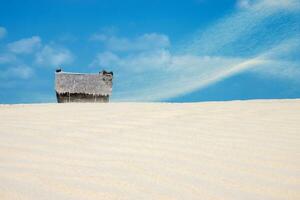 vissers hut Aan de strand met zandstorm en blauw lucht. foto