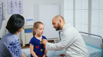 medisch beoefenaar luisteren meisje hartslag. gezondheidszorg arts dokter specialist in geneeskunde het verstrekken van Gezondheid zorg Diensten radiografisch behandeling examen in ziekenhuis kabinet foto