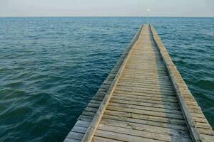 een houten pier strekt zich uit uit in de oceaan foto