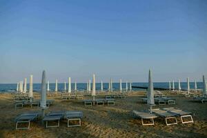 strand stoelen en paraplu's Aan de zand foto