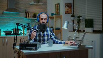 Mens blogger vervelend hoofdtelefoons en pratend over zijn levensstijl gedurende podcast van huis. creatief online tonen onair productie internet uitzending gastheer streaming leven inhoud, opname digitaal sociaal media communicatie foto