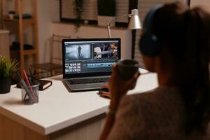 filmmaker bewerken video beeldmateriaal gedurende nacht tijd in huis keuken. inhoud Schepper in huis werken Aan montage van film gebruik makend van modern software voor bewerken laat Bij nacht. foto