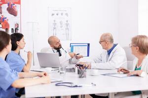 gezondheidszorg specialist pratend in conferentie kamer gedurende geneeskunde seminarie. kliniek deskundige therapeut bespreken met collega's over ziekte, geneeskunde professioneel foto