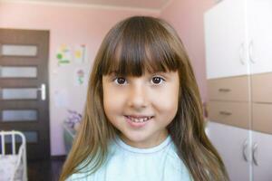 portret van een schattig wit meisje tegen de achtergrond van haar kamer. foto