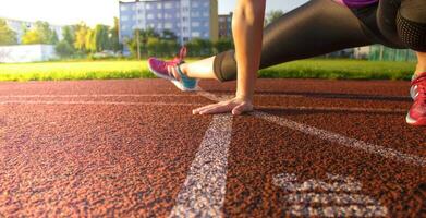 een vrouw verwarmt omhoog voordat opleiding Aan een openbaar sport- veld. foto