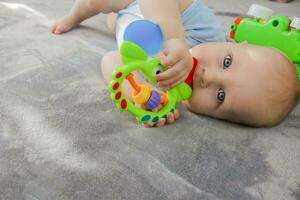 baby jongen aan het liegen Aan de bankstel spelen met een speelgoed. kopiëren ruimte. foto