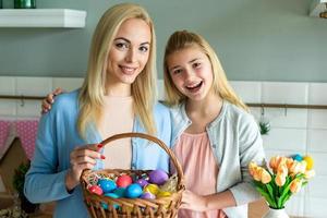 moeder en dochter houden een mand met paaseieren vast. foto