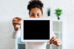 meisje met een tablet met een leeg scherm op een onscherpe achtergrond foto