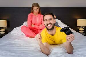 jong paar hebben spelen computerspelletjes in bed foto