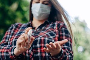 close-up, een meisje met een beschermend masker, desinfecteert haar handen foto