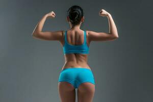 jong atletisch meisje shows spieren foto