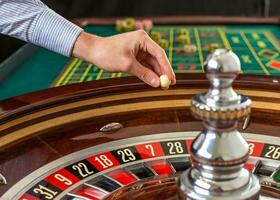 roulette wiel en croupier hand- met wit bal in casino foto