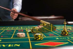 croupier verzamelt chips gebruik makend van stok in casino. foto