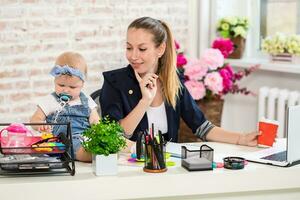 mam en zakenvrouw werken met laptop computer Bij huis en spelen met haar baby meisje. foto