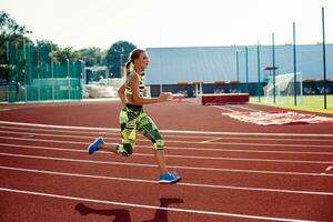 mooi jong vrouw oefening jogging en rennen Aan atletisch bijhouden Aan stadion. foto