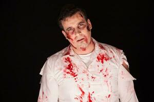 eng en bloederig zombie over- zwart achtergrond. halloween kleding. foto