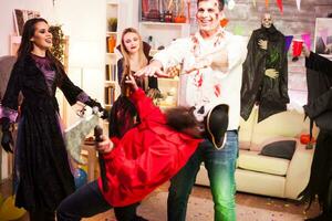 groep van vrienden spelen spellen terwijl vieren halloween in hun kostuums. foto